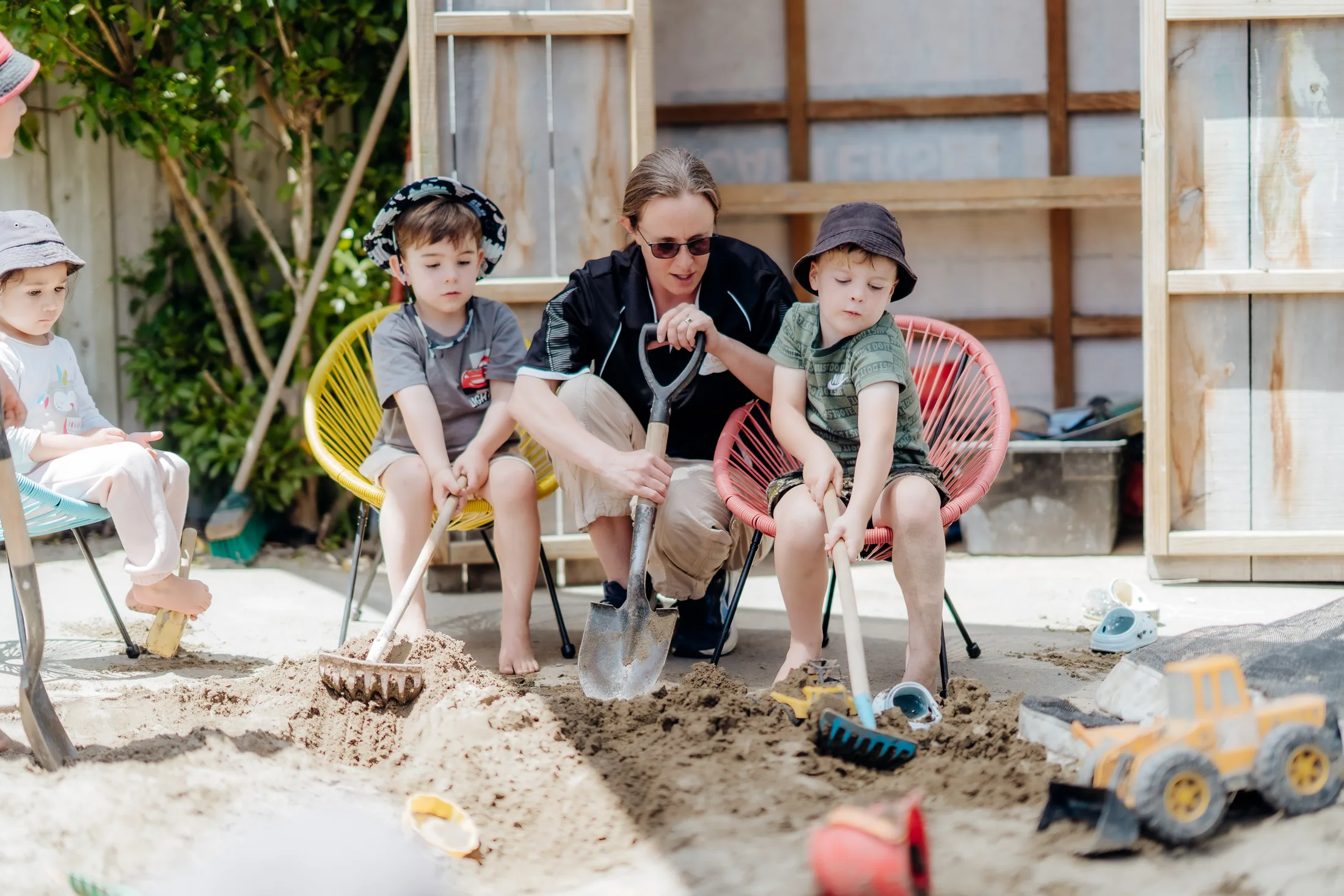 Children and a kaiako collaborating in the sandpit