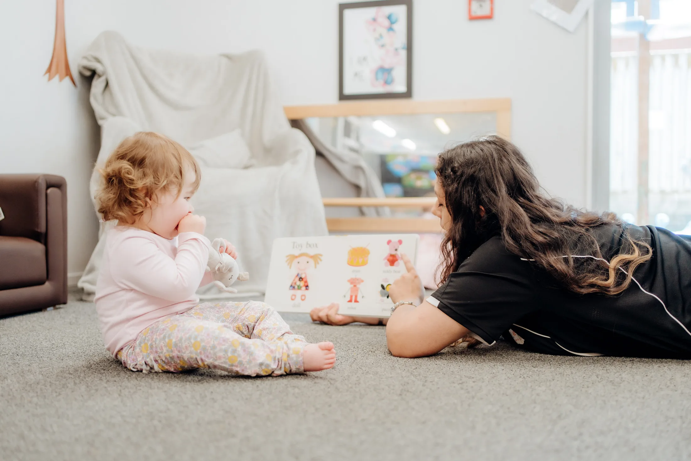 A kaiako reading with two young children